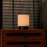 Cordless table lamp Dou Small with Nero Marquina black marble base lit on a vintage wooden dresser