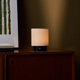 Cordless table lamp Dou Small on a walnut cabinet in Nero Marquina black marble beside a framed botanical print