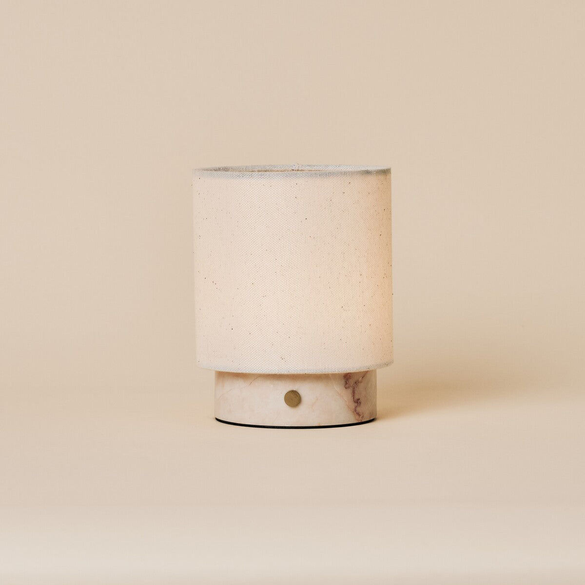 Dou Small cordless table lamp in Rosa Aurora marble with pale pink veining on a plain backdrop