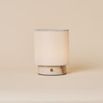 Dou Small cordless table lamp in Rosa Aurora marble with pale pink veining on a plain backdrop