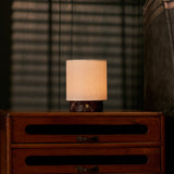 Cordless table lamp Dou Small with Rosso Levanto red marble base on a vintage wooden dresser at dusk