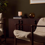 Cordless Dou Small Silver Travertine Table Lamp glowing on a dark wood sideboard in an olive-green living room