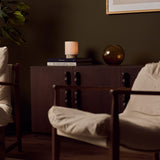 Cordless Dou Small Silver Travertine Table Lamp glowing on a dark wood sideboard in an olive-green living room