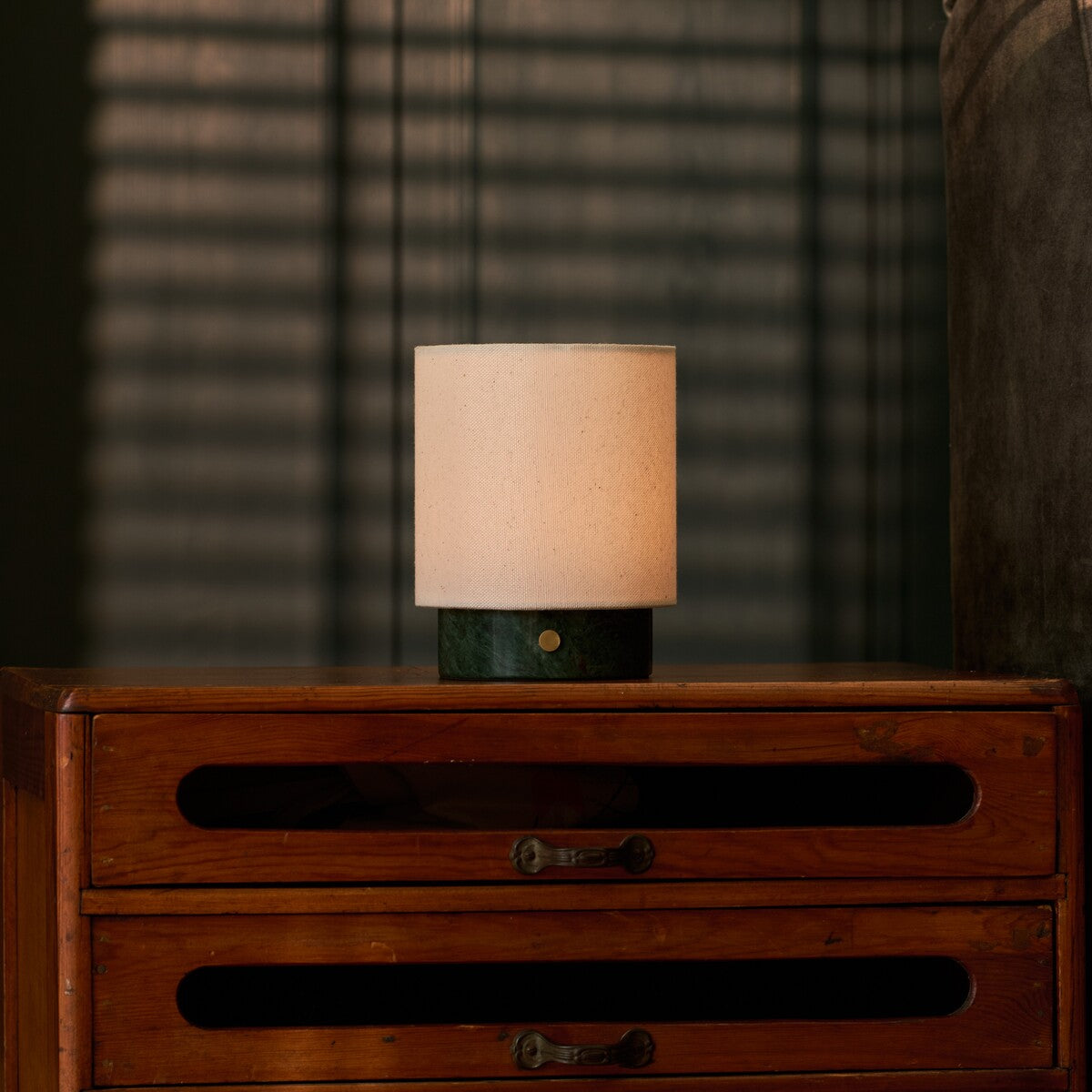 Cordless table lamp Dou Small with Verde Alpi green marble base on a vintage wooden dresser