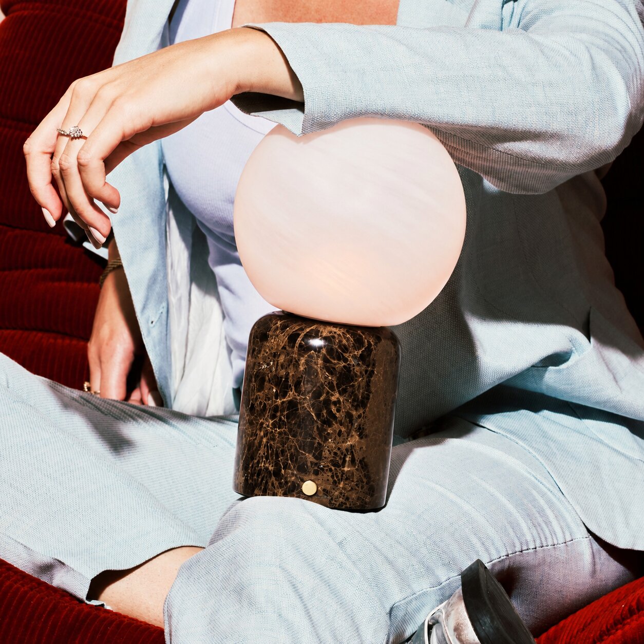 Metsu Large rechargeable table lamp, round glass shade and dark Emperador marble base held close-up