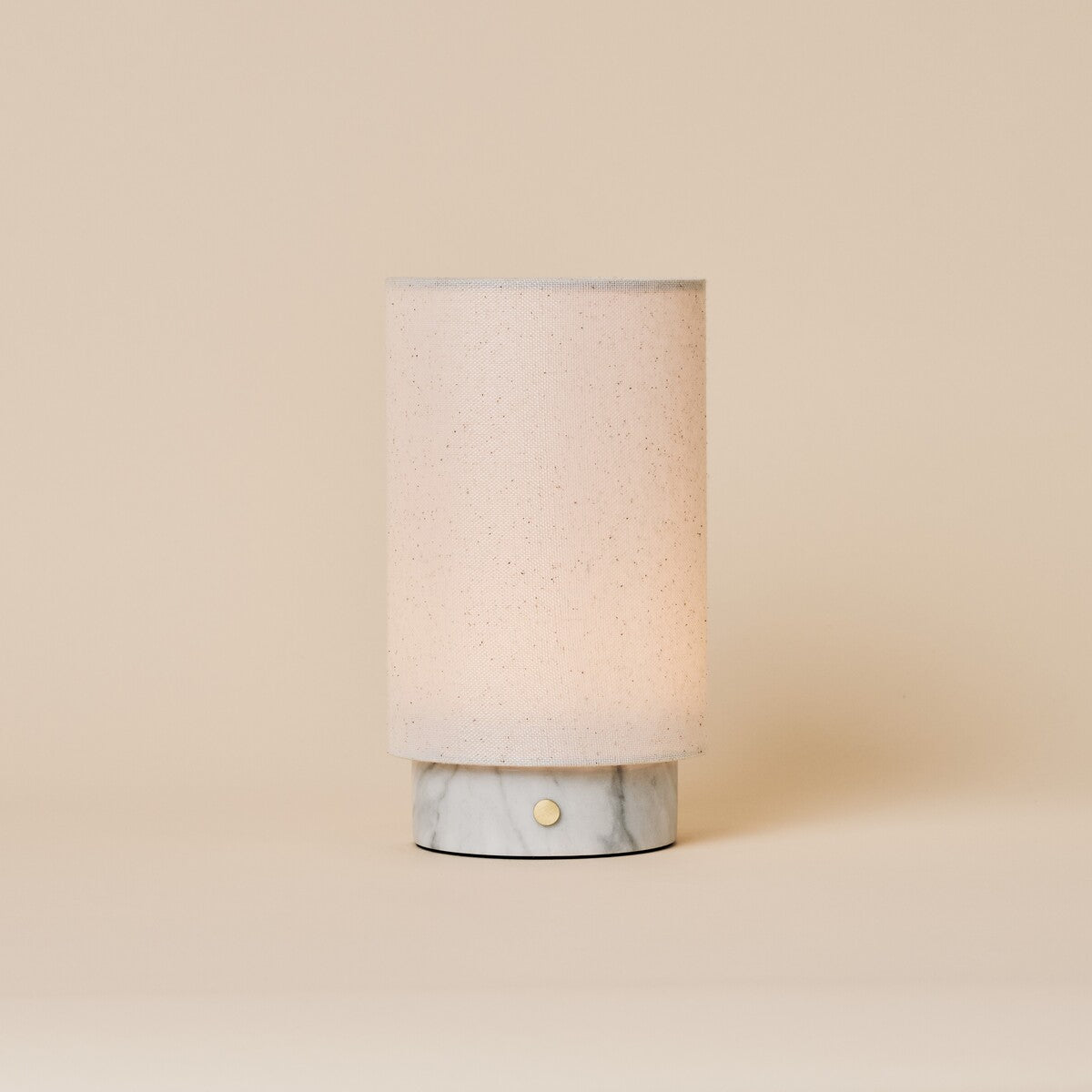 Floris rechargeable table lamp with white Bianco Statuarietto marble base on a cream studio backdrop