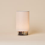 Floris rechargeable table lamp in Calacatta Viola marble with linen shade on a plain studio backdrop