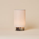 Floris rechargeable table lamp in Calacatta Viola marble with linen shade on a plain studio backdrop