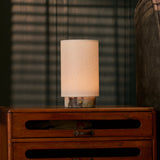 Floris rechargeable table lamp in Calacatta Viola marble glowing on a bedroom dresser before striped blinds