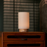 Oplaadbare tafellamp Floris in roze Calacatta Vionaro marmer naast een gestreepte fauteuil