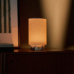 Tavellio Floris cordless table lamp in Calacatta Vionaro white marble glowing on a sideboard against a warm lit wall