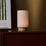 Tafellamp oplaadbaar Floris in geel marmer, warm gloeiend op een notenhouten dressoir