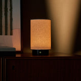 Nero Marquina marble rechargeable table lamp glowing softly on a dark wood cabinet at night