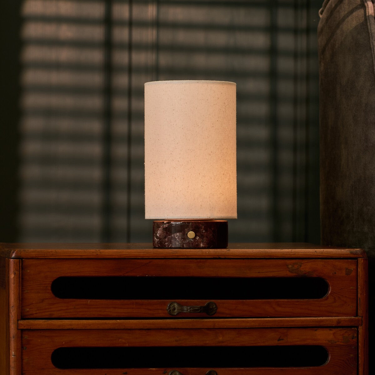 Floris Rosso Levanto marbre lampe de table rechargeable Tavellio – sur une commode vintage – ombres de store vénitien sur le mur