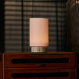 Floris Silver Travertine lampe de table sans fil Tavellio – sur une commode en bois près d'un store vénitien, silhouette éclairée le soir