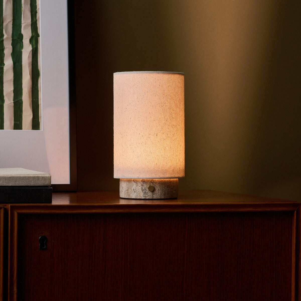 Floris Silver Travertine lampe de table rechargeable Tavellio – sur meuble bas devant un mur vert olive, veinures grises du socle visibles