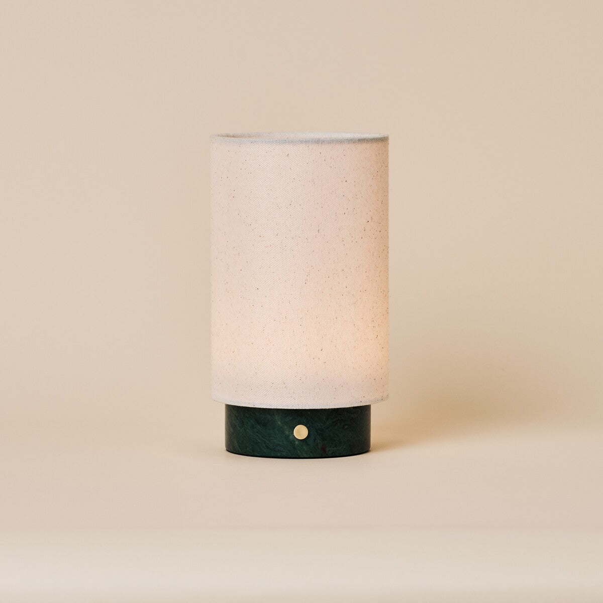 Floris Verde Alpi Marble rechargeable table lamp with linen shade on a beige studio backdrop