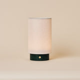 Floris Verde Alpi Marble rechargeable table lamp with linen shade on a beige studio backdrop