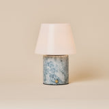 Oplaadbare tafellamp Hooch in Blue Calcite marmer met glanzende kegelvormige kap op beige achtergrond