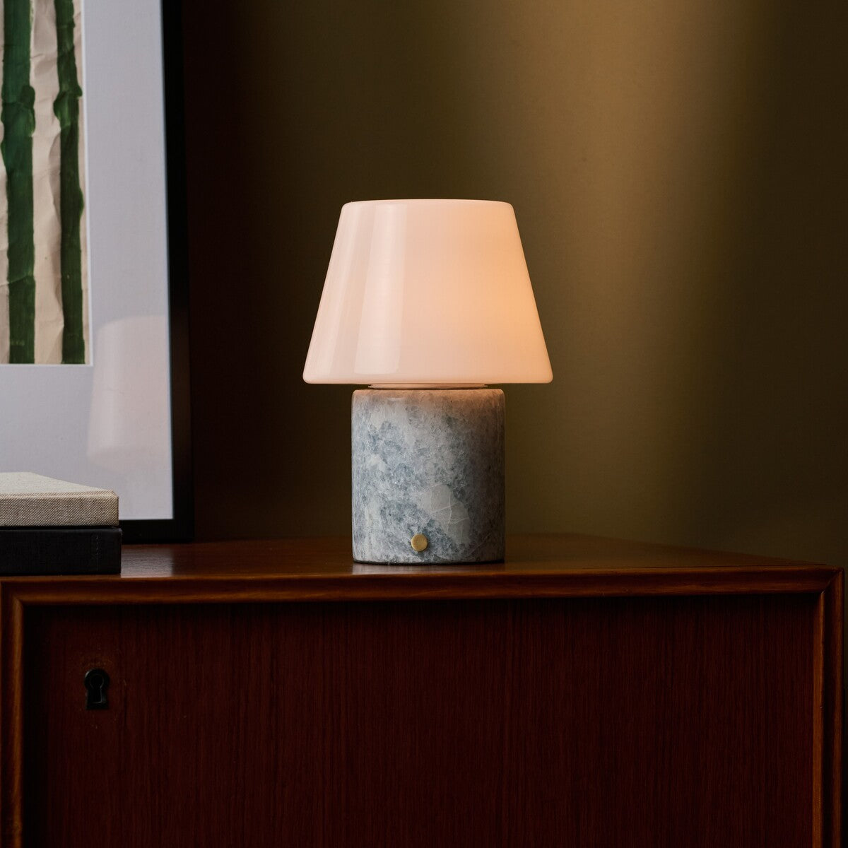 Tafellamp oplaadbaar Hooch in Blue Calcite marmer op een houten dressoir bij ingelijste kunst