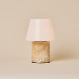 Oplaadbare tafellamp Hooch in Honey Onyx marmer met kegelvormige glazen kap op beige achtergrond