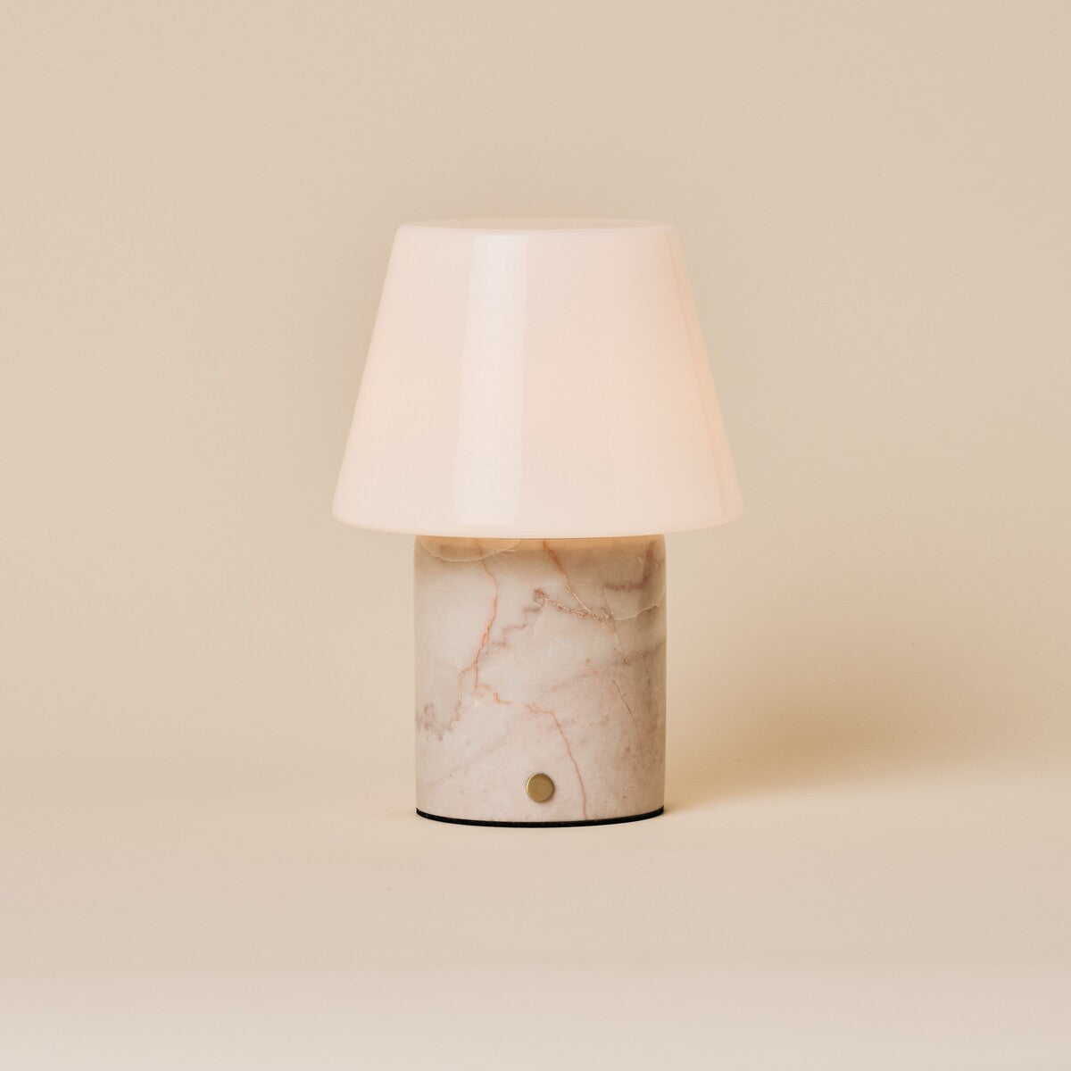 Oplaadbare tafellamp Hooch in Rosa Aurora marmer met kegelvormige glazen kap op beige achtergrond