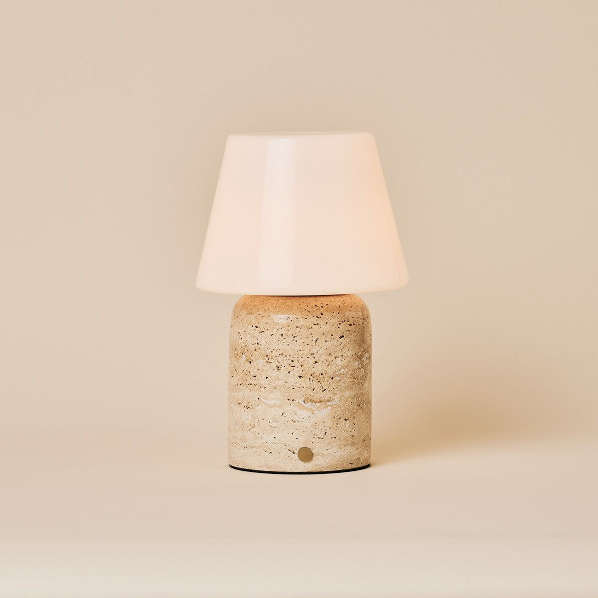 Oplaadbare tafellamp Hooch Large in beige travertin met taps toelopende opaalglazen kap op een effen achtergrond