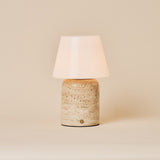 Oplaadbare tafellamp Hooch Large in beige travertin met taps toelopende opaalglazen kap op een effen achtergrond