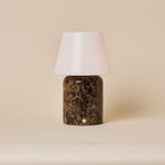 Oplaadbare tafellamp Hooch Large Emperador Dark Marble met glanzende witte conische kap op een beige achtergrond