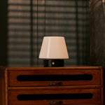 Oplaadbare tafellamp Hooch Small Nero Marquina Marble brandend op een dressoir voor gestreepte lamellen
