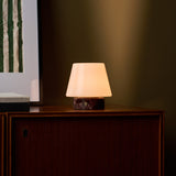 Tafellamp oplaadbaar Hooch Small Rosso Levanto Marble brandend op een donkere kast naast gestreepte kunst