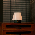 Oplaadbare tafellamp Hooch Small Verde Alpi Marble brandend op een dressoir voor gestreepte lamellen