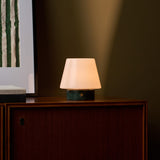 Tafellamp oplaadbaar Hooch Small Verde Alpi Marble gloeiend zacht op een kast in de avondschemering