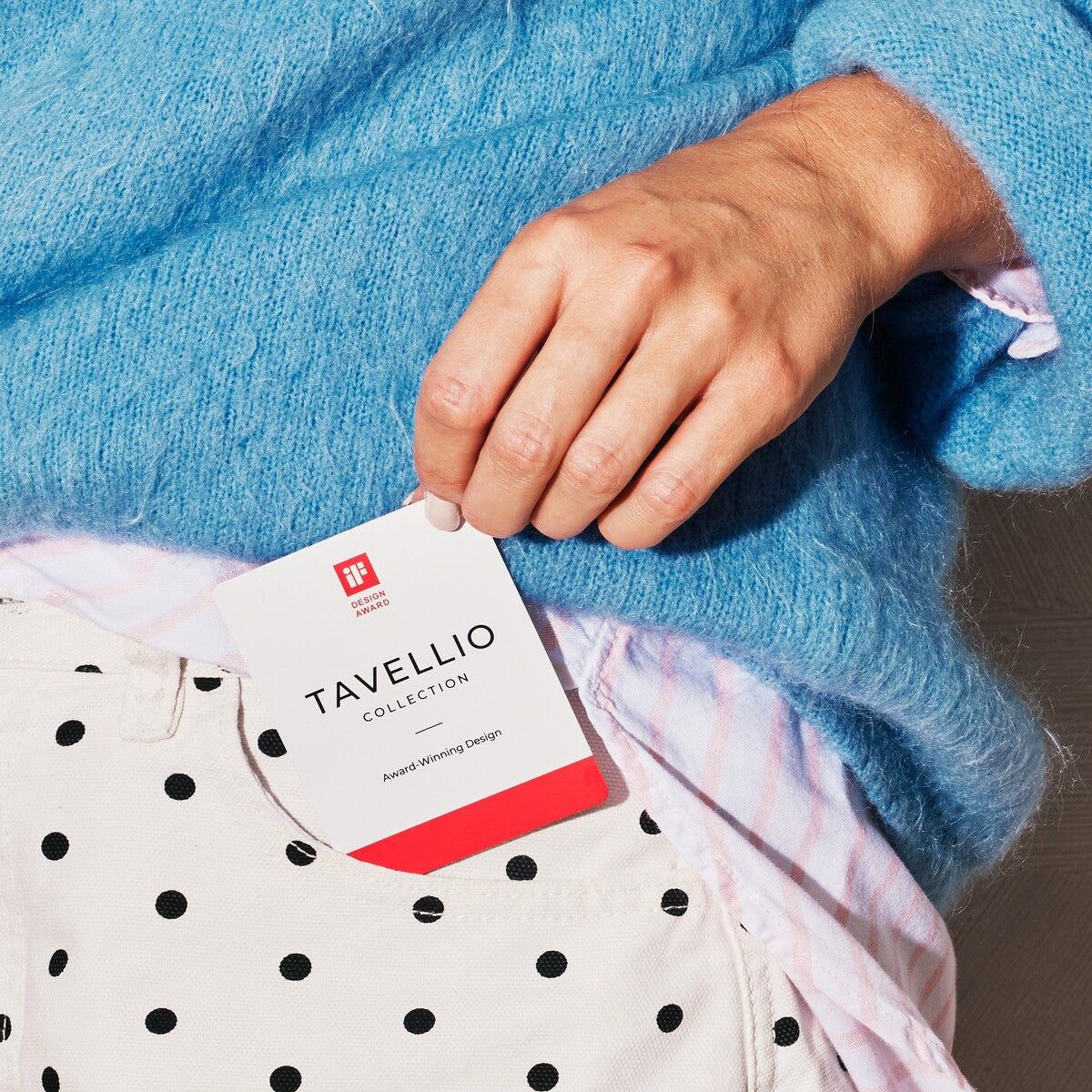 Hand holding the Tavellio iF Design Award card recognising the marble table lamp collection