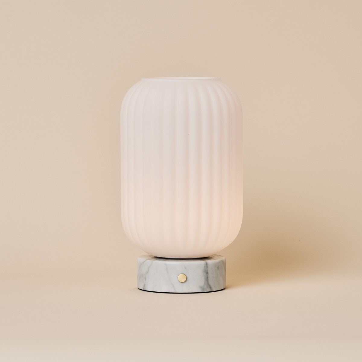 Oplaadbare tafellamp Kota met Bianco Statuarietto wit marmer en geribbeld glazen kapje op neutrale achtergrond