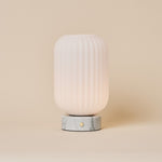 Oplaadbare tafellamp Kota met Bianco Statuarietto wit marmer en geribbeld glazen kapje op neutrale achtergrond
