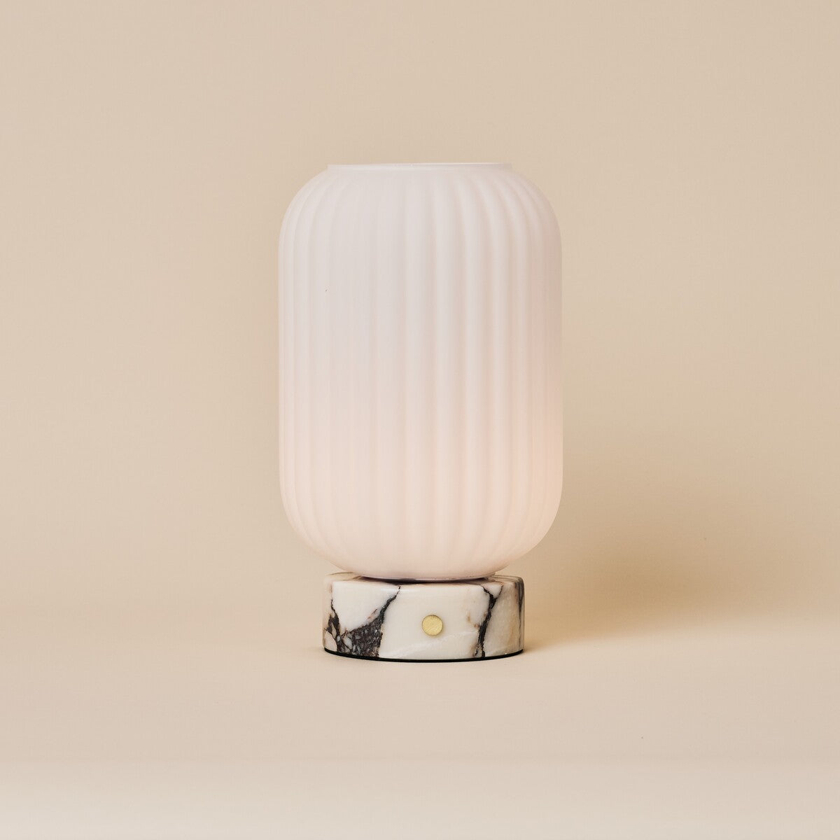 Oplaadbare tafellamp Kota met Calacatta Vionaro marmeren voet en geribbeld glazen kapje op beige achtergrond
