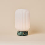 Oplaadbare tafellamp Kota met Ice Green marmeren voet en geribbeld glazen kapje op een neutrale achtergrond