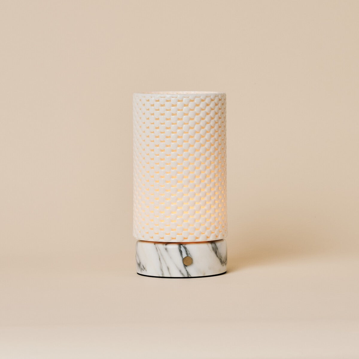 Tafellamp Luna oplaadbaar in Arabescato marmer en porselein, studiofoto tegen een beige achtergrond.