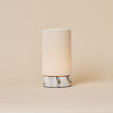 Tafellamp Luna oplaadbaar in Arabescato marmer en porselein, studiofoto tegen een beige achtergrond.