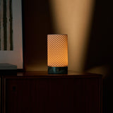 Oplaadbare tafellamp Luna met Ice Green marmeren voet gloeit warm tegen een schemerige woonkamerwand