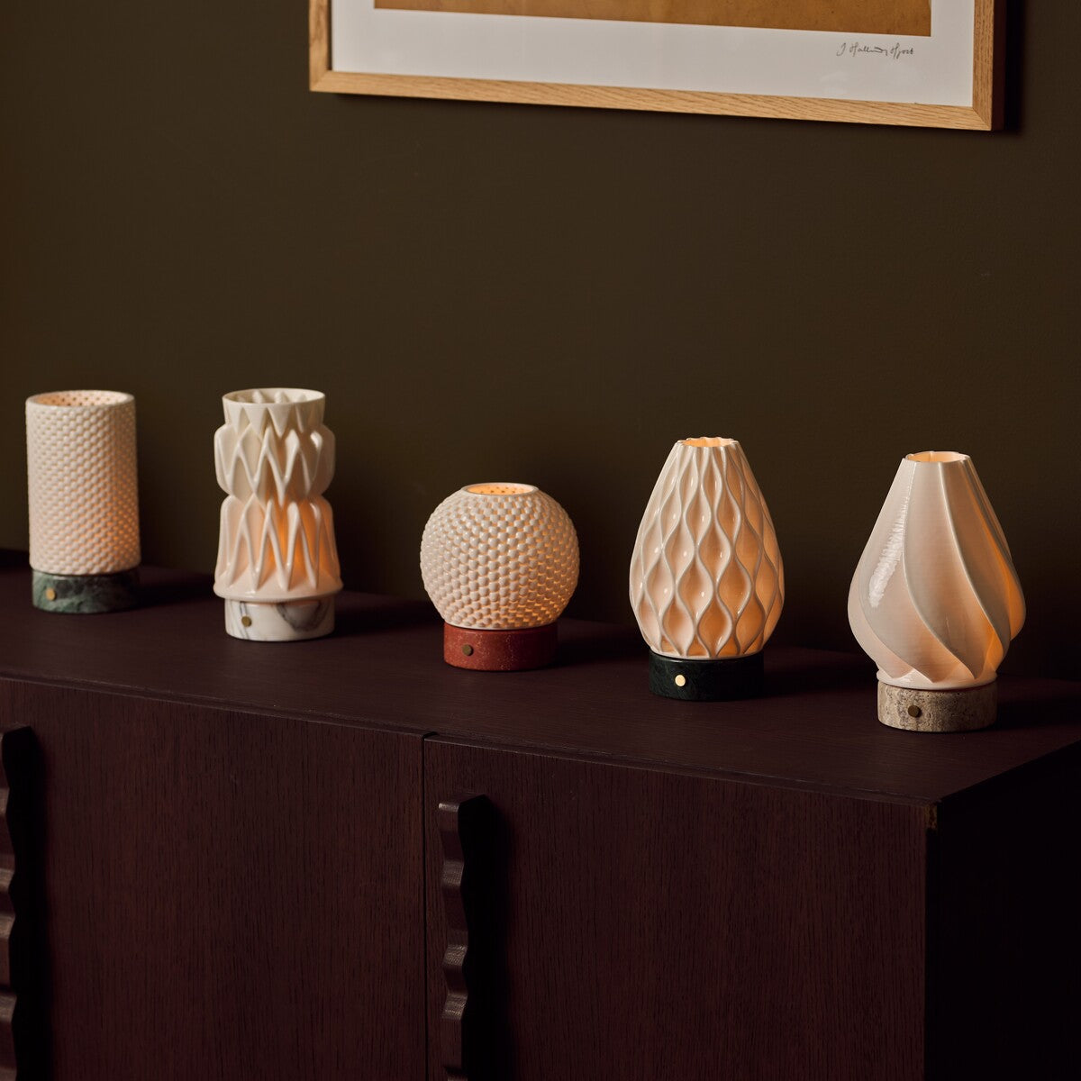 Textured porcelain lampshade collection for Tavellio rechargeable table lamps, displayed on a wooden sideboard