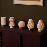 Textured porcelain lampshade collection for Tavellio rechargeable table lamps, displayed on a wooden sideboard