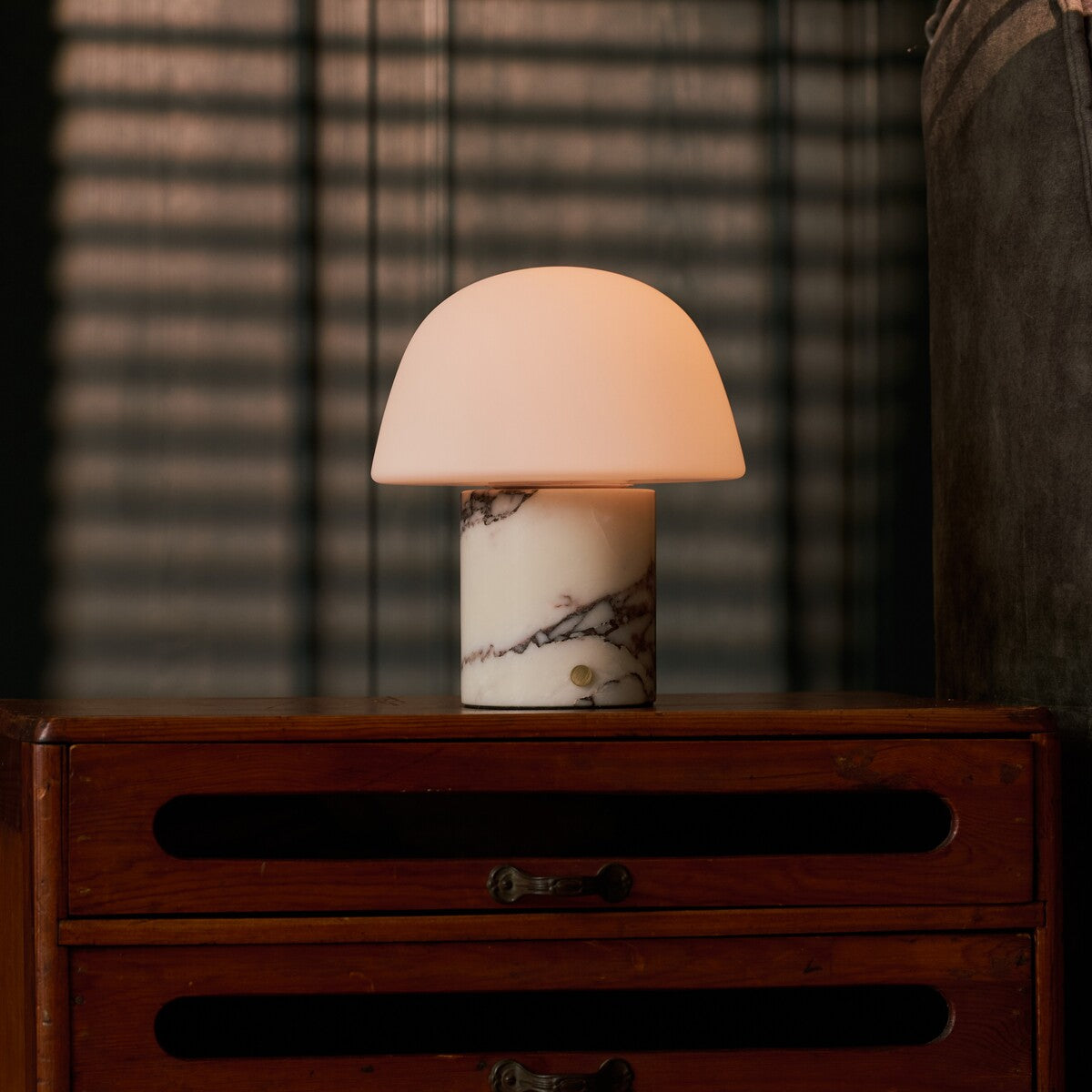 Tafellamp oplaadbaar Maes in Calacatta Vionaro marmer, brandend op een donker houten dressoir