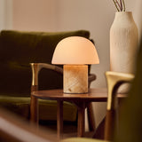 Tafellamp oplaadbaar Maes Honey Onyx marmer op een bijzettafel tussen een olijfgroene fauteuil en keramische vaas