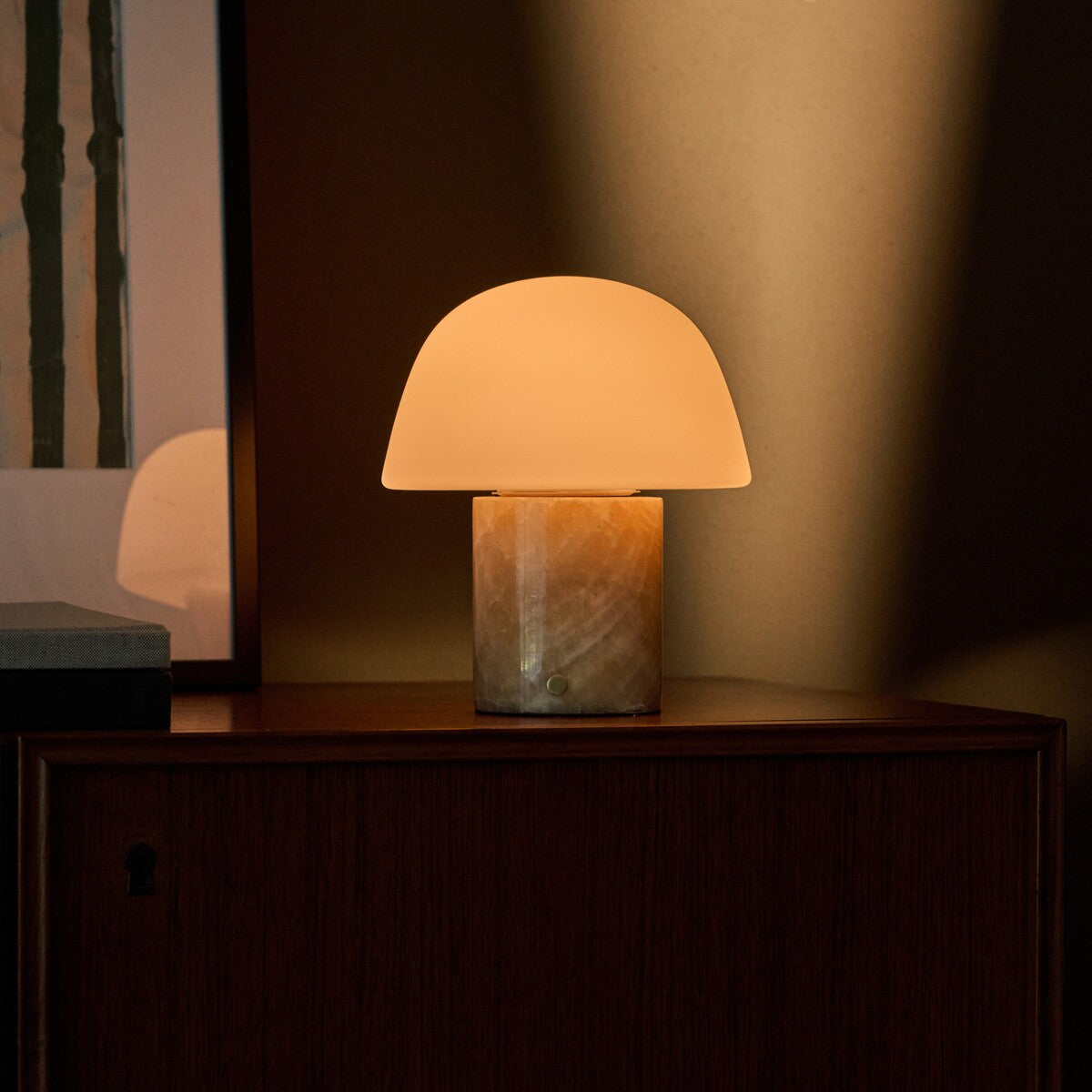Oplaadbare tafellamp Maes Honey Onyx marmer met lamellen-schaduw op een houten ladekast in de slaapkamer