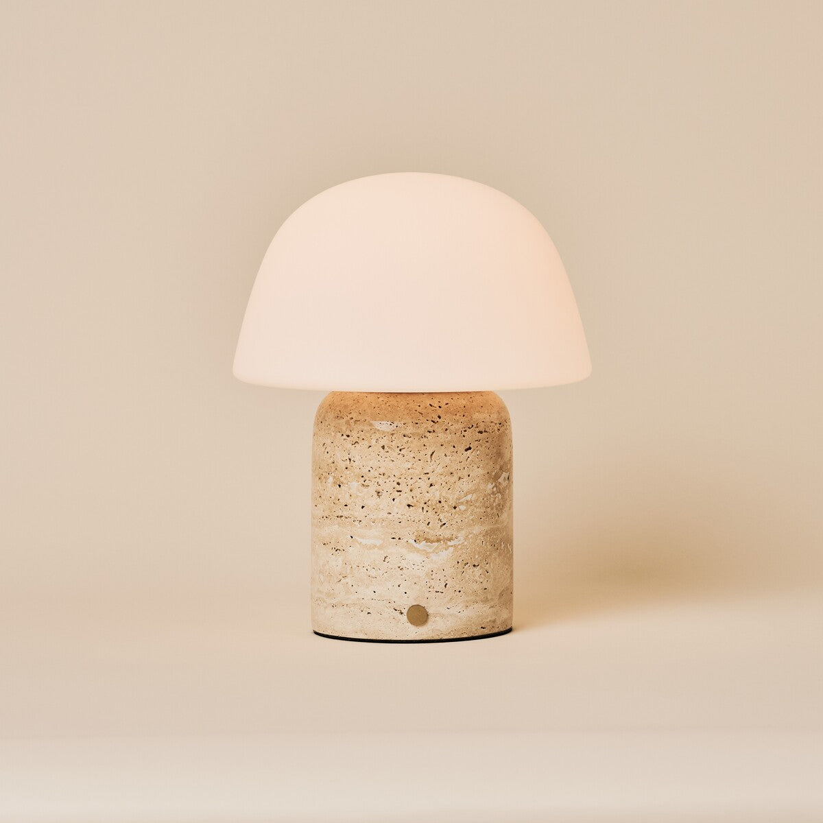Oplaadbare tafellamp Maes Large in classic travertine met melkglazen bolvormige kap op crème achtergrond