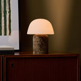 Oplaadbare tafellamp Maes Large met Emperador donker marmeren voet, warm gloeiend op beige achtergrond