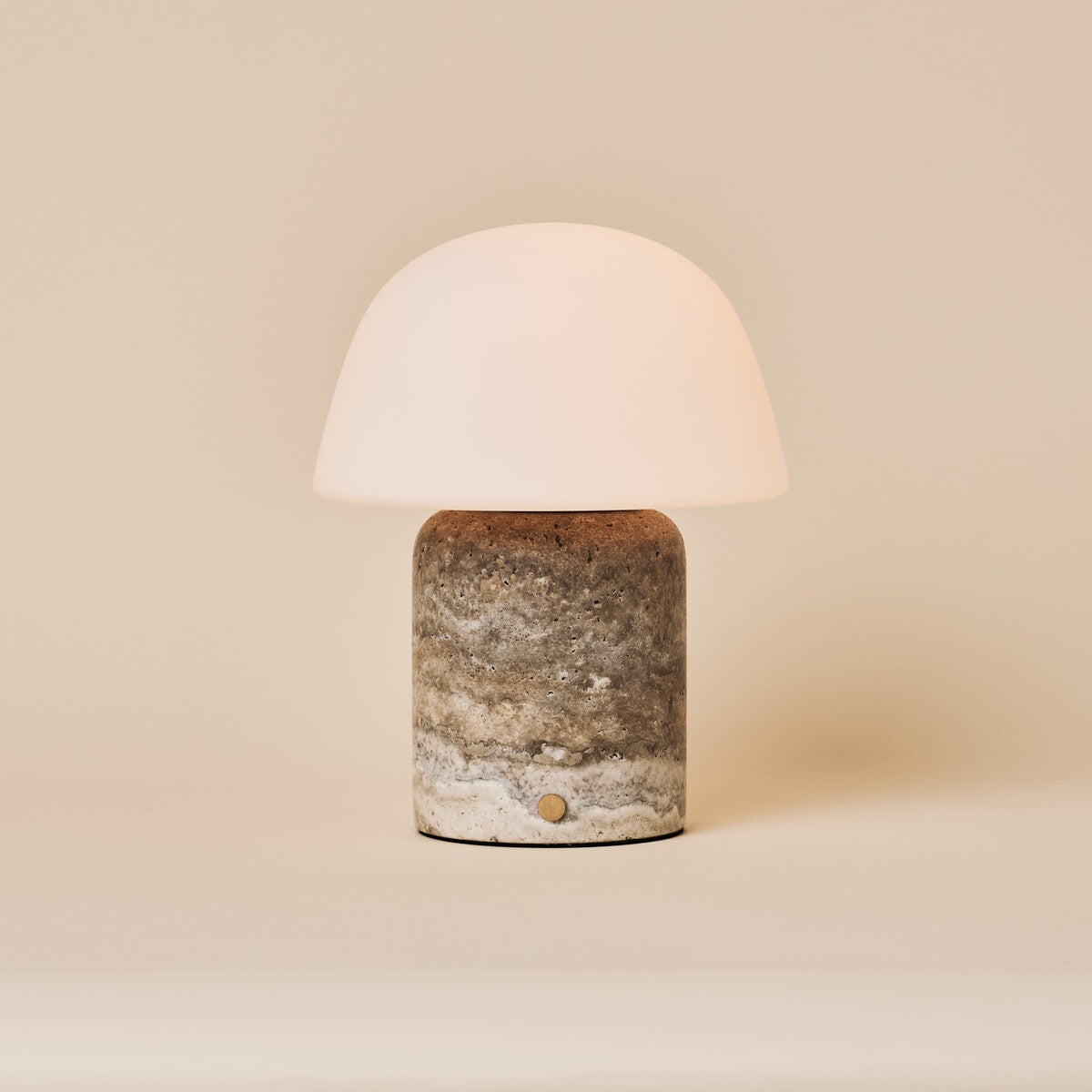 Oplaadbare tafellamp Maes Large in silver travertine met melkglazen bolvormige kap op beige achtergrond