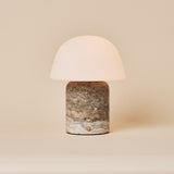 Oplaadbare tafellamp Maes Large in silver travertine met melkglazen bolvormige kap op beige achtergrond